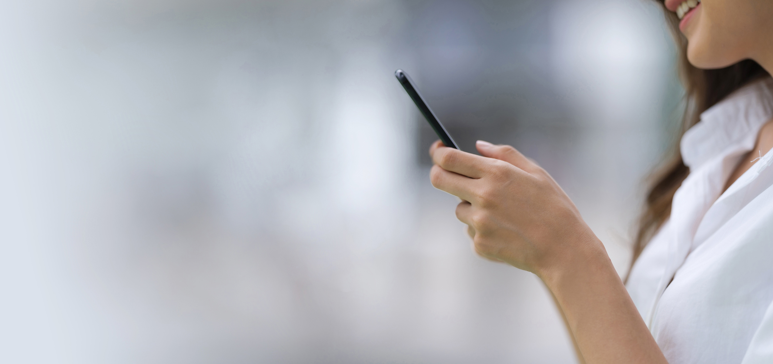 Outdoors Portrait of Happy Young Woman Using a Phone